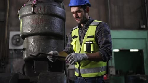 Engineer is working at machine part factory.