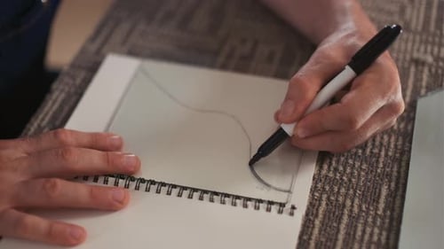 Hand Drawing with Pen on White Paper