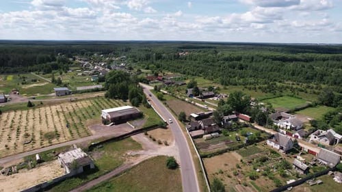 Aerial View of a Village Among Forests with Private Backyards and an Unfinished Cottage
