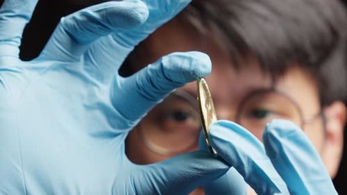 Examination of gleaming golden bitcoin cryptocurrency