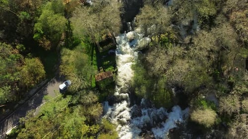 Overhead View Of Cascade Flowing Through The River Amid The Trees In The Forest. - aerial shot