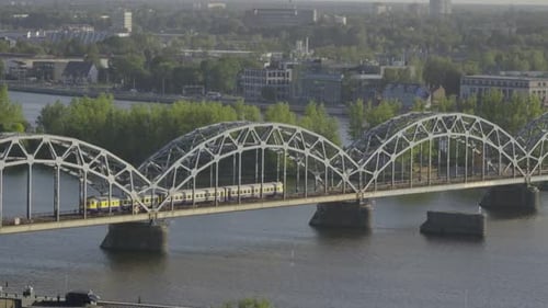 Train passing over arched bridge inside European city
