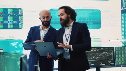 Colleagues Analyze Stock Market Data in Modern Office