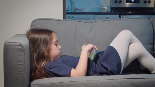 Girl Relaxes on Couch with Smartphone