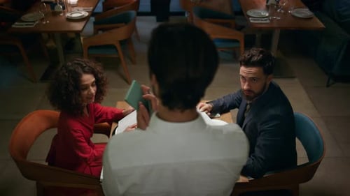 Waiter Serving Multiethnic Couple in Luxury Cafe Bar. Romantic Partners Order Dinner