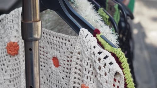 Colorful Knitted Garments Hanging on Hangers at a Local Craft Market for Everyone to See
