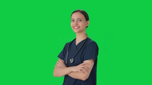 Portrait of Happy Indian female doctor standing crossed hands Green screen