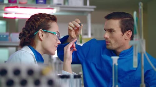 Medical laboratory research teamwork analyzing liquid sample in science lab
