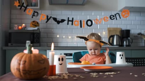 Adorable Infant Plays at Halloween Decorated Table