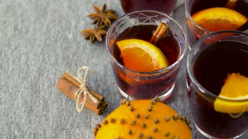 Christmas And Seasonal Drinks Concept - Glasses Of Hot Mulled Wine With Orange Slices And Aromati...
