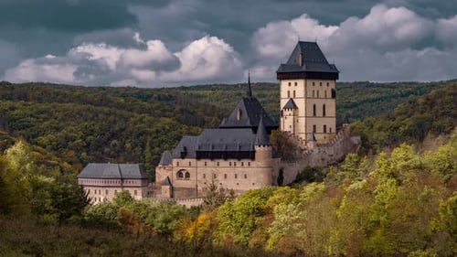 Aerial view of the beautiful Karlštejn Castle, towering solemnly on the hill surrounded by the dense