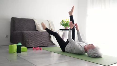 Senior Woman Exercising on a Mat in Her Home
