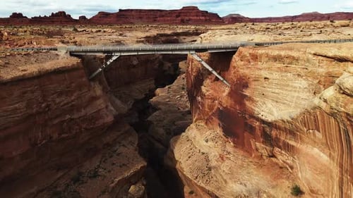 Drone approach to steel bridge over deep Utah rock canyon near Canyonlands