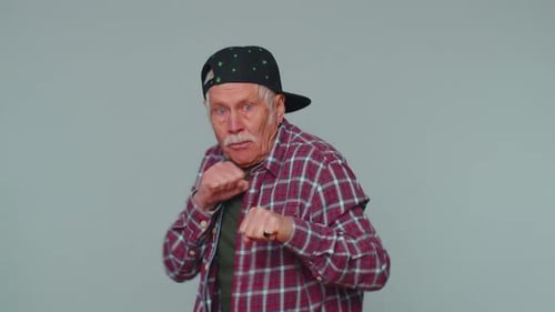 Senior Man Boxing Against Gray Background