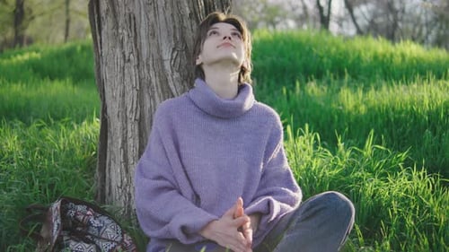 Teen Girl Relaxing by Tree in Sunny Park