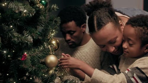 Family Decorating Christmas Tree Together at Home