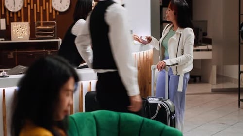 Asian Traveler Receiving Passport and Room Access Card