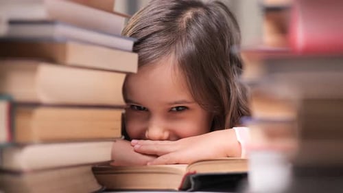 Close Up Portrait of Little Girl with Books Child Among Stacks of Books