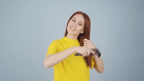 Woman combing her hair. Hair care.