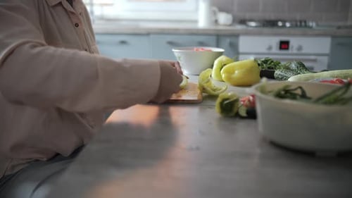 Woman cutting vegetables for healthy lunch in kitchen