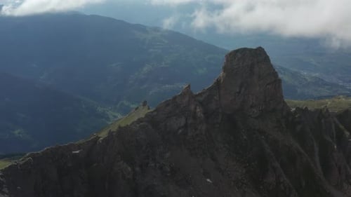 Drone flying over rocky mountain slope and reveal green valley