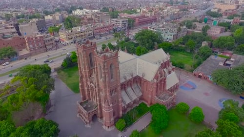 Aerial view of a beautiful old Church in the city, Traffic is moving on the other side road of the C