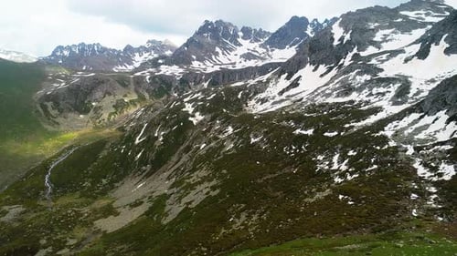 Aerial View of Green Mountains with Snow Capped Peaks