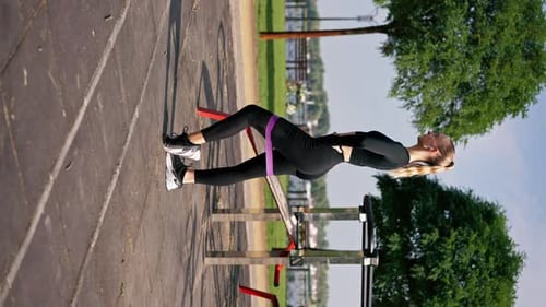 Active Woman Exercising Glutes Outdoors with Resistance Band