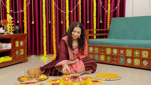 Woman Lighting Oil Lamps for Diwali Celebration