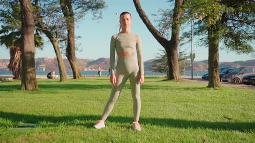 Sportswoman Standing in Summer Park After Morning Workout Arms Crossed Looking at Camera