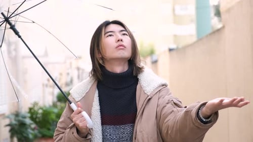 Smiling Man Walking on Urban Street With Umbrella
