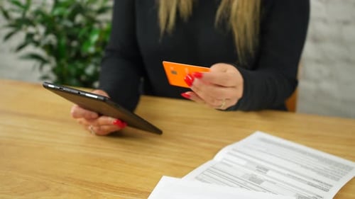 Woman using Tablet with Credit Card at Desk