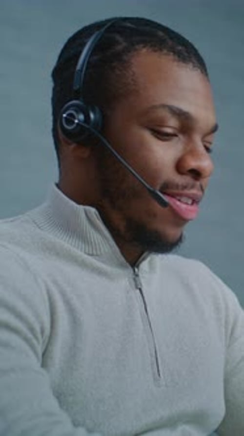 Professional Young Adult Man Using Headset in Office