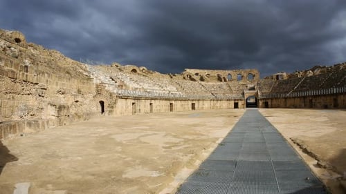 Panorama: Interior of the Roman amphitheatre of El Djem in Tunisia under dramati