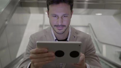 Young Adult Using Tablet on Escalator