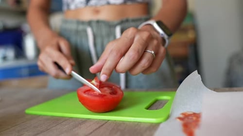 Tomatoes Being Cut on Green Board in Cozy Kitchen Preparing Meal with Natural Organic Ingredients