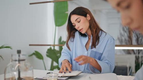 Businesswoman Talking Mobile Phone with Client Office Manager Checking Schedule