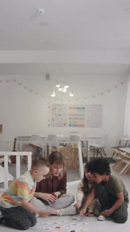 Teacher and Children Learning with Cards on Floor