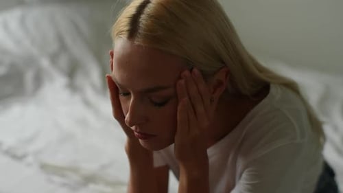 Closeup Highangle View Face of Unhappy Millennial Young Woman Holding Head in Hands Feeling Anxiety