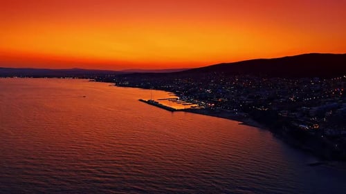 Rote Sonnenuntergangsreflexion auf der dunklen Meeresoberfläche.
