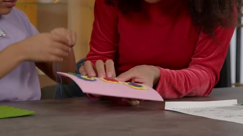 Closeup of Child Hands with Needle and Threads Sewing DIY Kids Bag