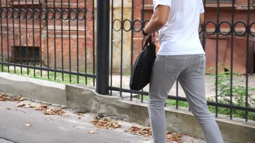 Young Man in Casual Wear Running Through Urban Street Follow to Businessman with Briefcase Hurrying