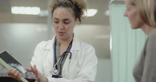 Doctor talking to Patient in Doctors Office about Medical X-ray on Digital Tablet
