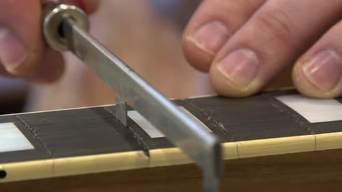 Freet Saw corta una ranura en el diapasón de ébano de una guitarra eléctrica en la tienda
