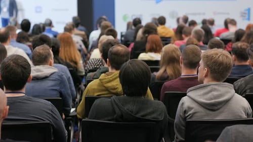 Conference Audience Listening To Speaker Presentation Indoors