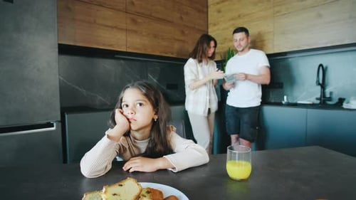 The Daughter Feels Lonely at the Table While Her Parents are Distracted By Their Own Tasks Adding a
