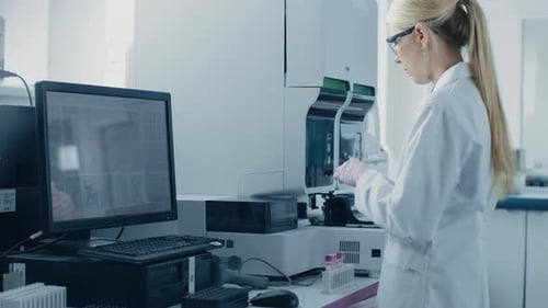Female Scientist Works With Automated Medical Testing Machine
