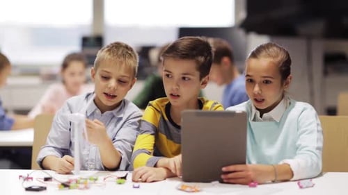 Enthusiastic Children Collaborate on Technology Project in Classroom