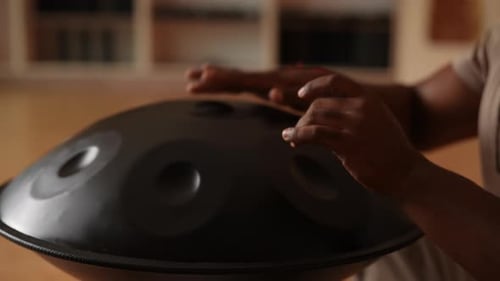 Black Male Hands Playing Tongue Drum Musical Instrument Metal Drum with Cut Steel Tongues and Unique