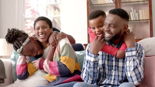 Happy Family Embracing on a Sofa at Home
